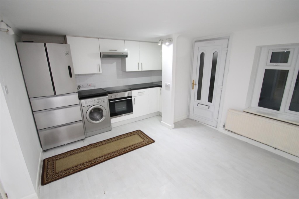 Lot: 168 - MID-TERRACE HOUSE FOR IMPROVEMENT - Lower ground floor flat living area with kitchen